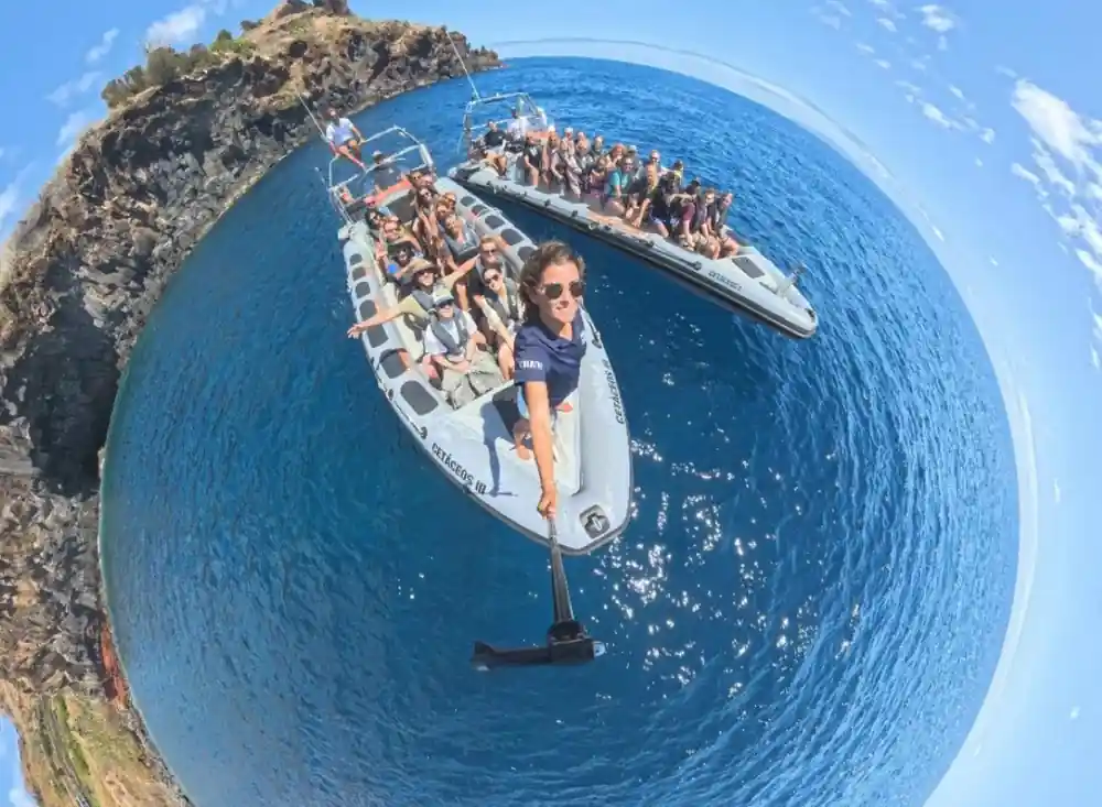 a wide fisheye frame of the whole boat load of guests waving from the tubes